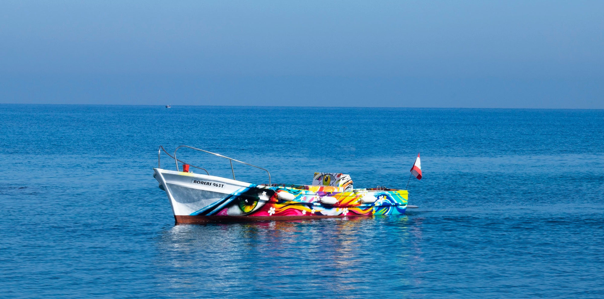 Colorful boat on a calm blue sea with a clear sky